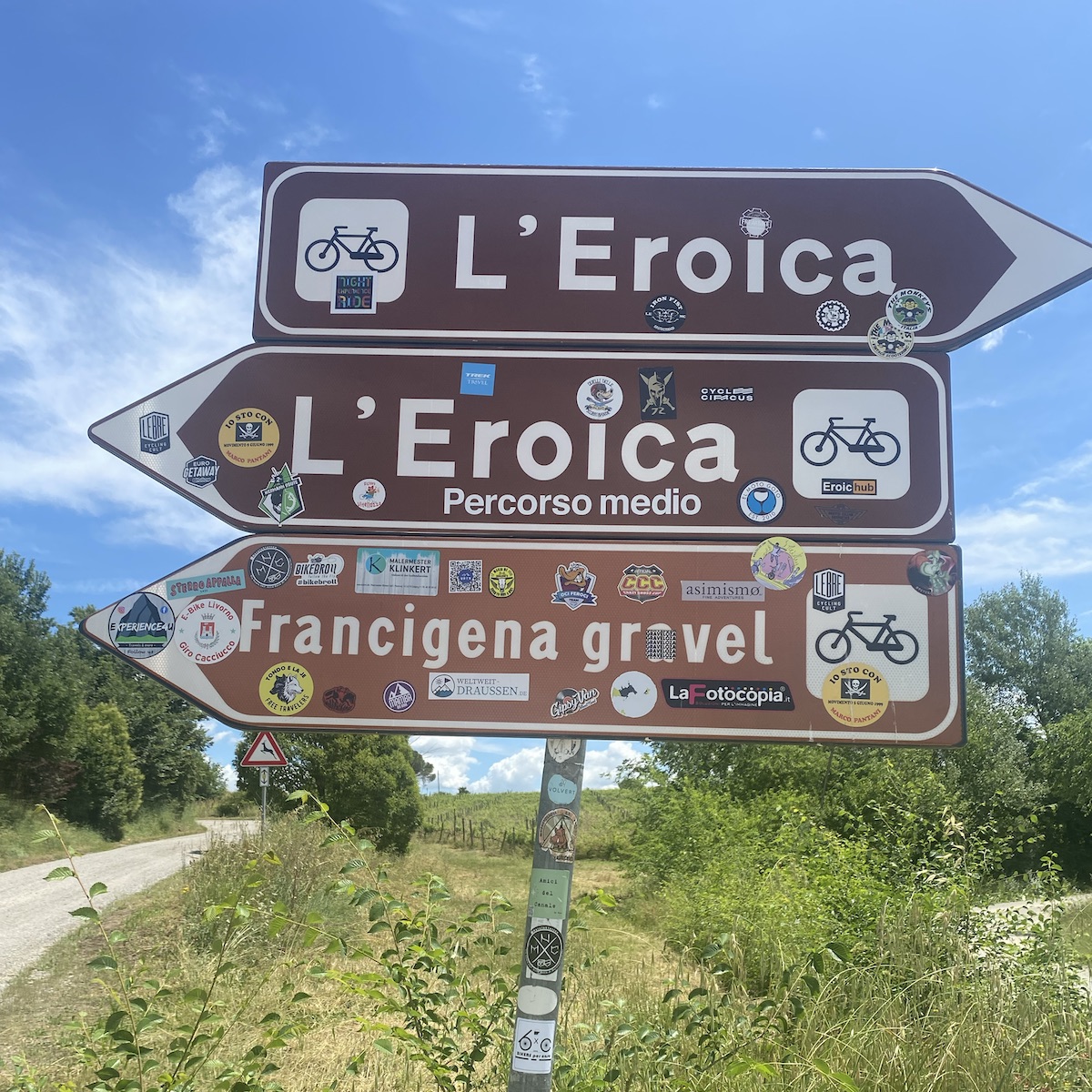 Signposts on the Eroica cycling route covered with cyclists' stickers