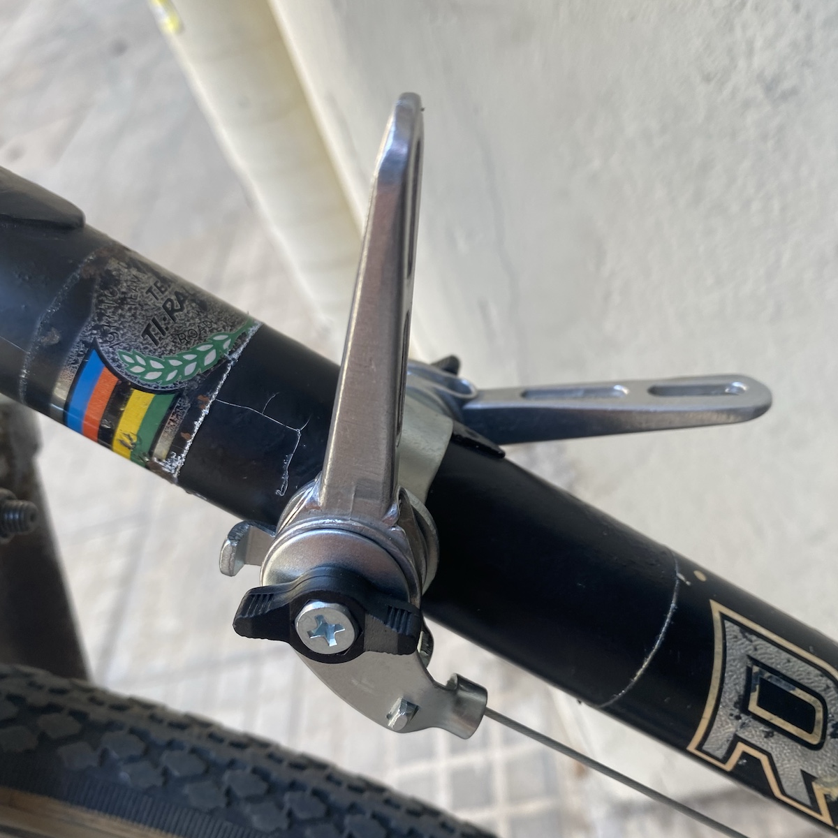 Friction shifters attached to a bracket on the downtube of a black bicycle frame