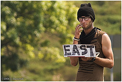 Hitch-hiker holding a sign that reads East